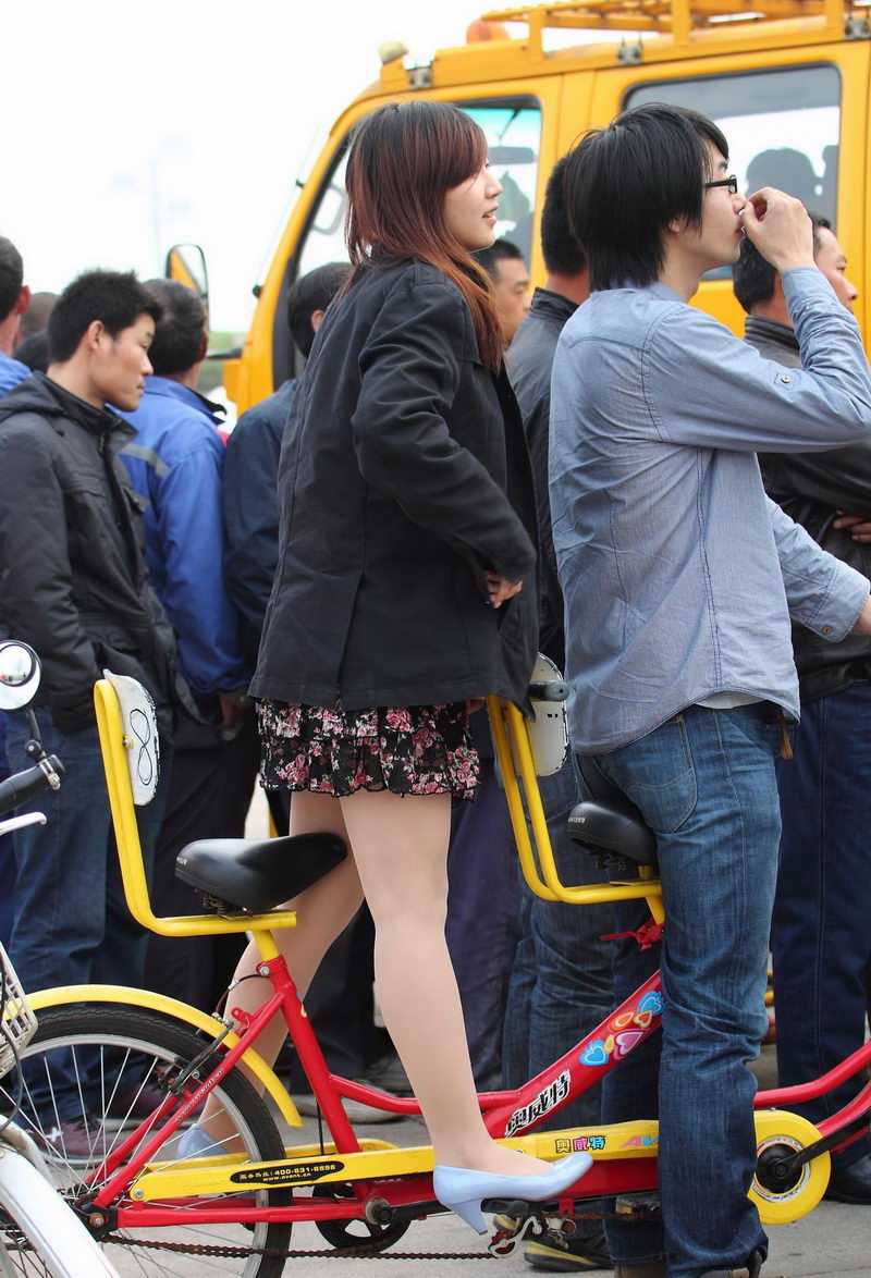 骑双人自行车的花裙子女生