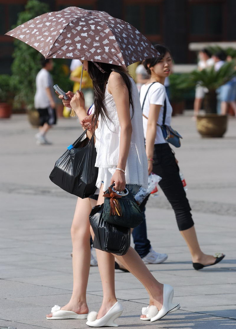 街拍夏日喝冰镇矿泉水的美眉