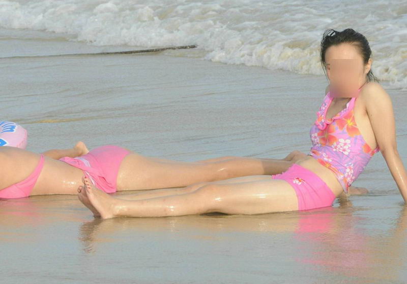 银沙海滩的泳装年轻妈妈