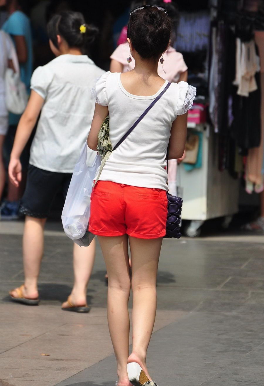 街拍一个打遮阳伞的红短裤女孩秀美腿